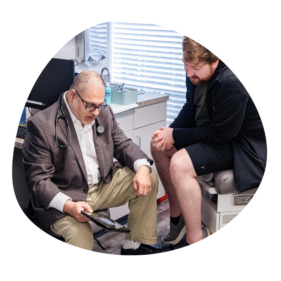 doctor-Aboughali-discussing-health-info-with-patient-primary-care-clinic.png